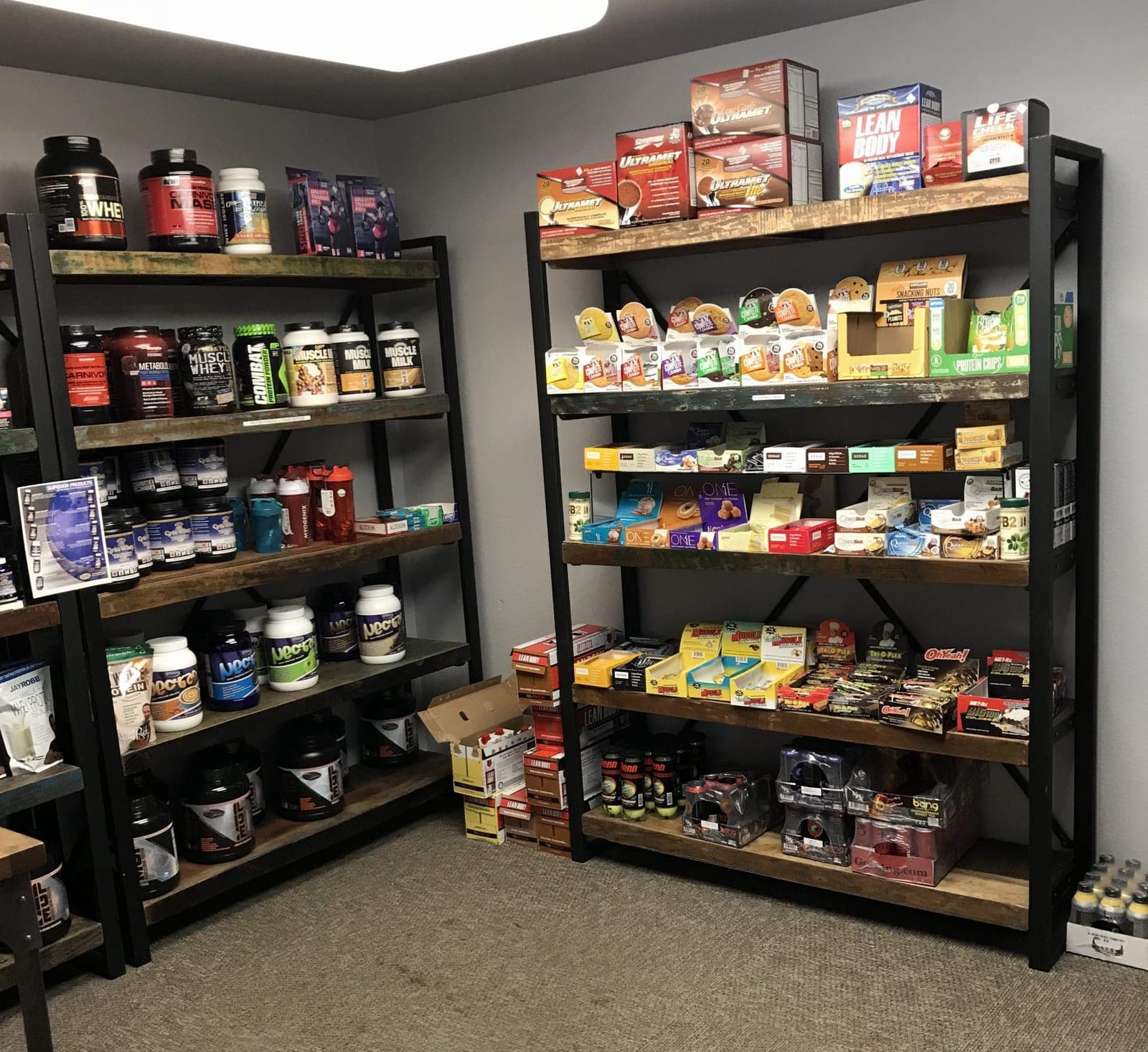 CNE's in-gym supplement shop: shelves stocked with protein, bars, and recovery drinks